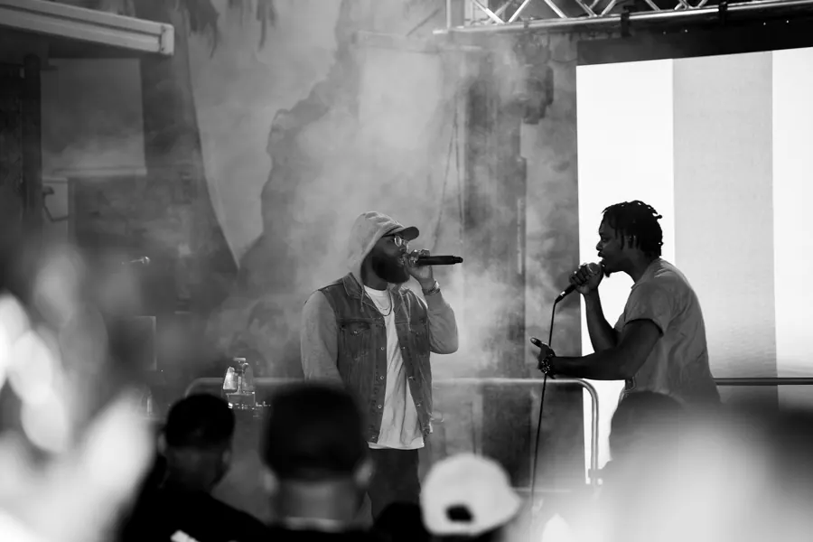 Black-and-white photo of two performers on a smoky stage