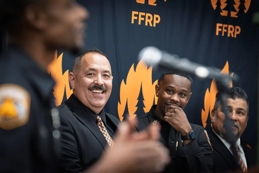 Panel of speakers laughing in front of an FFRP backdrop