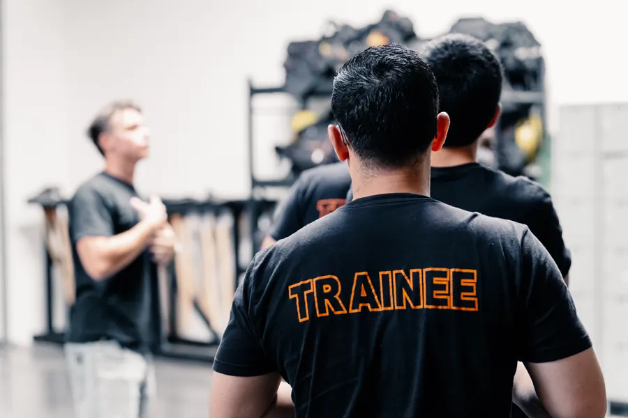 Fire academy trainees listening to an instructor in an equipment bay